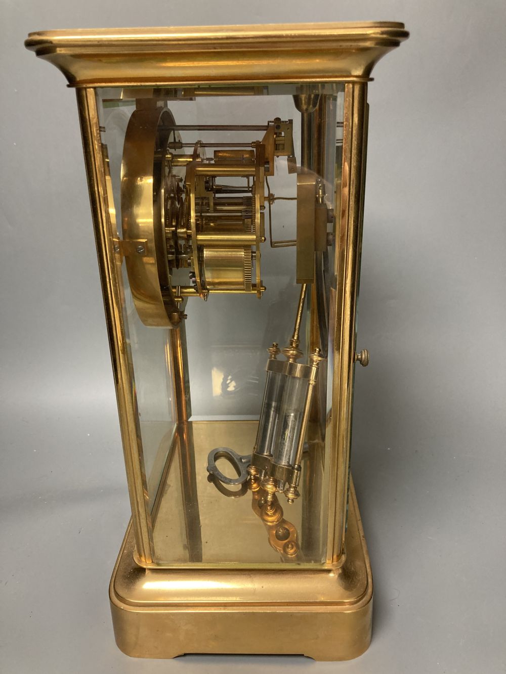 A French brass four glass mantel clock, retailed by J W Benson, with visible Brocot escapement and mercury filled pendulum bob, 33cm hi